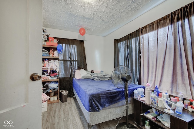 bedroom featuring hardwood / wood-style floors and a textured ceiling