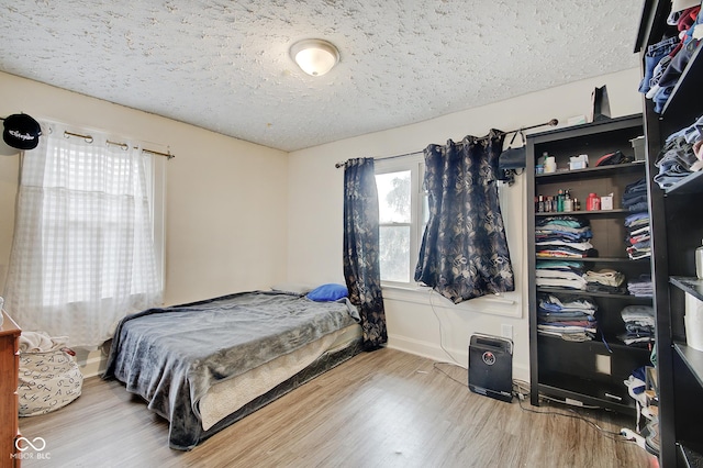 bedroom featuring hardwood / wood-style flooring and a textured ceiling