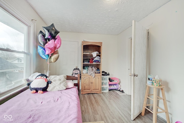 bedroom featuring a textured ceiling and light hardwood / wood-style floors