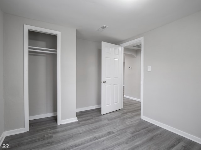 unfurnished bedroom featuring hardwood / wood-style flooring and a closet