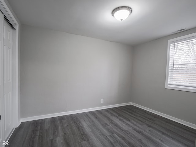 unfurnished room featuring dark wood-type flooring