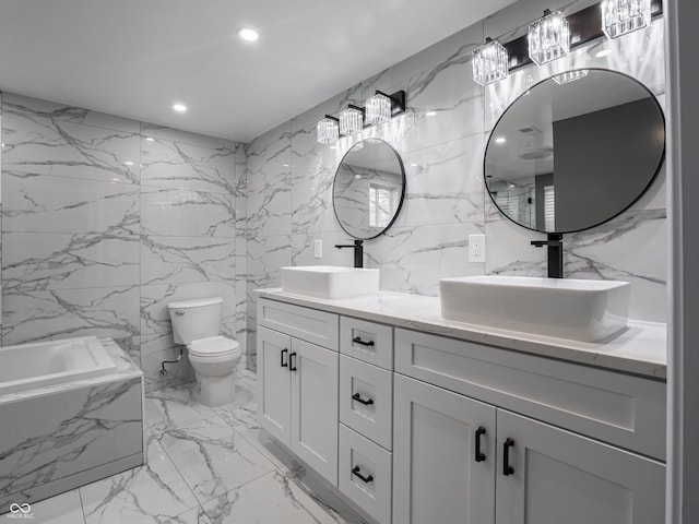 bathroom with vanity, toilet, tile walls, and a tub