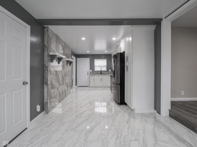 interior space featuring white cabinets, stainless steel fridge, and sink