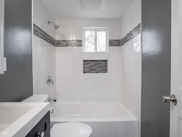 full bathroom featuring vanity, tiled shower / bath combo, and toilet