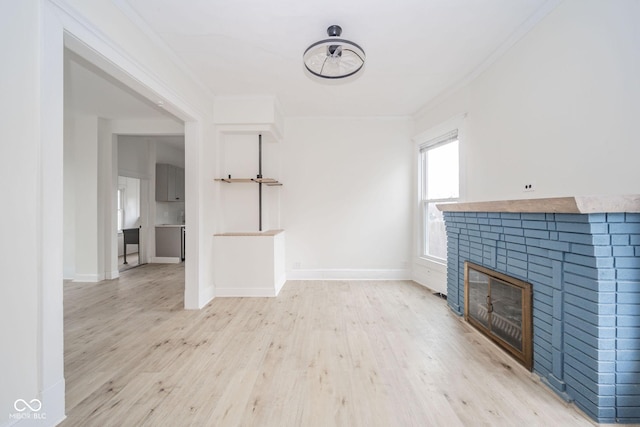 unfurnished living room with light wood-type flooring and crown molding