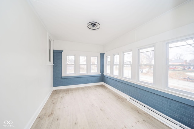 unfurnished sunroom with baseboard heating and plenty of natural light