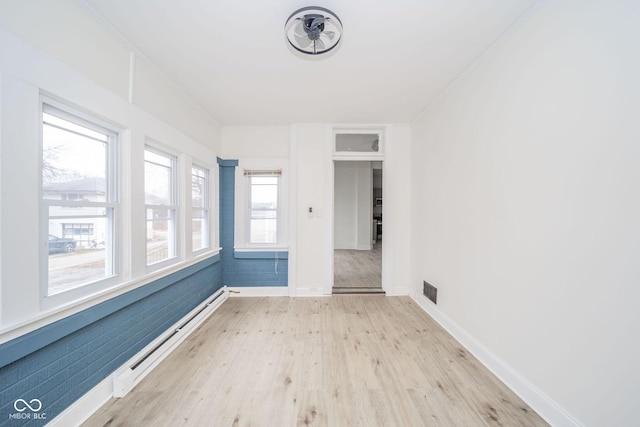 unfurnished room featuring ornamental molding, a baseboard radiator, and light wood-type flooring