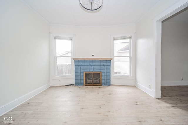 unfurnished living room featuring light hardwood / wood-style flooring, plenty of natural light, and crown molding