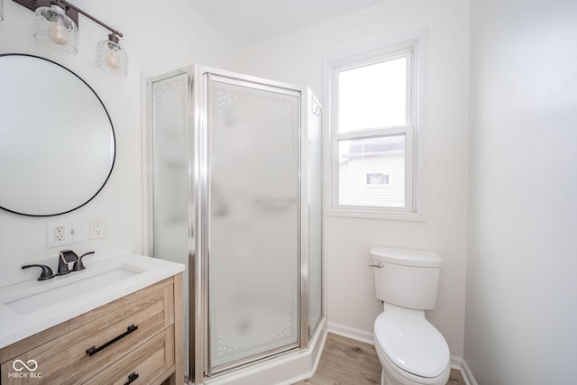 bathroom featuring hardwood / wood-style flooring, vanity, toilet, and walk in shower