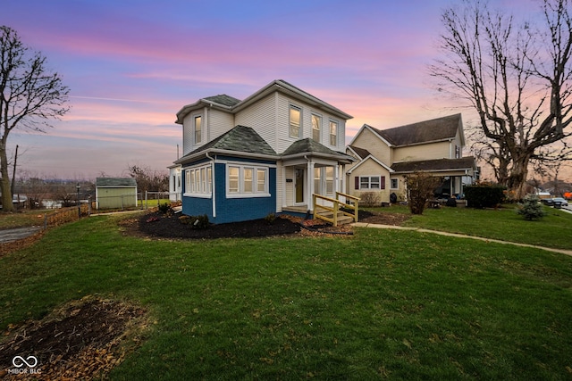 front facade featuring a yard and a storage shed