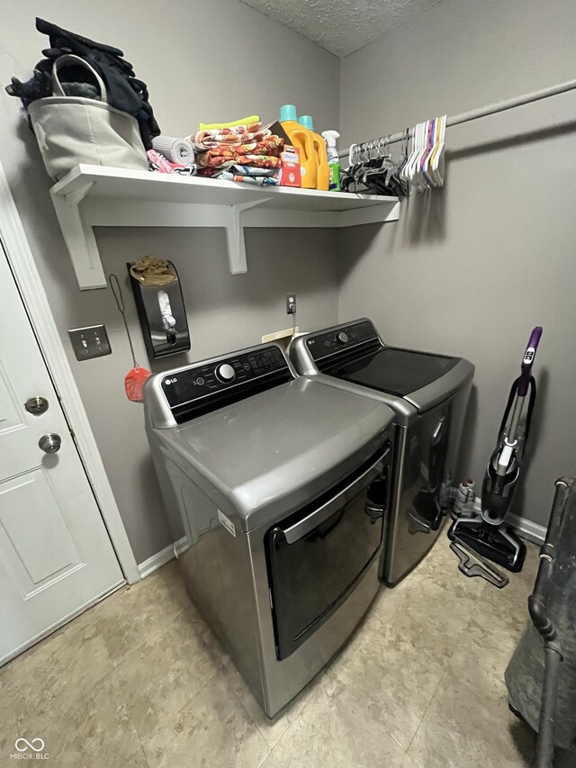 washroom with independent washer and dryer and a textured ceiling