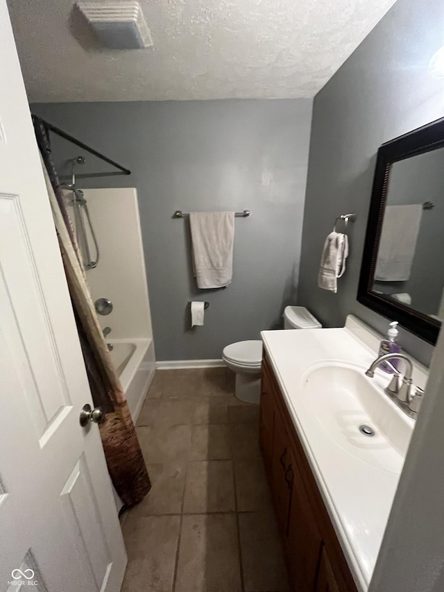 full bathroom featuring tile patterned floors, a textured ceiling, toilet, vanity, and shower / tub combo