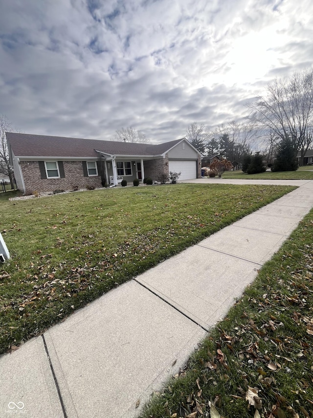 ranch-style house featuring a garage and a front lawn