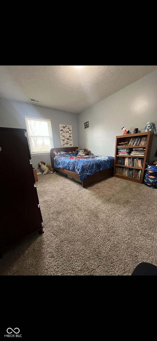 bedroom with carpet flooring and a textured ceiling