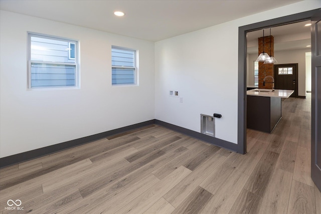 spare room with sink and hardwood / wood-style flooring