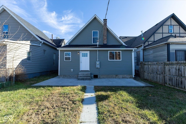 back of property with a lawn and a patio