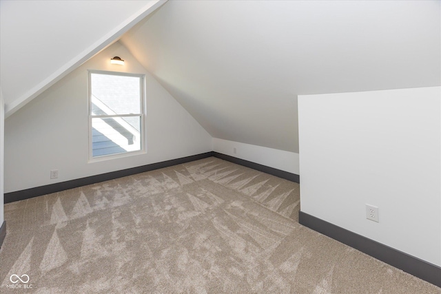 additional living space featuring light carpet and vaulted ceiling