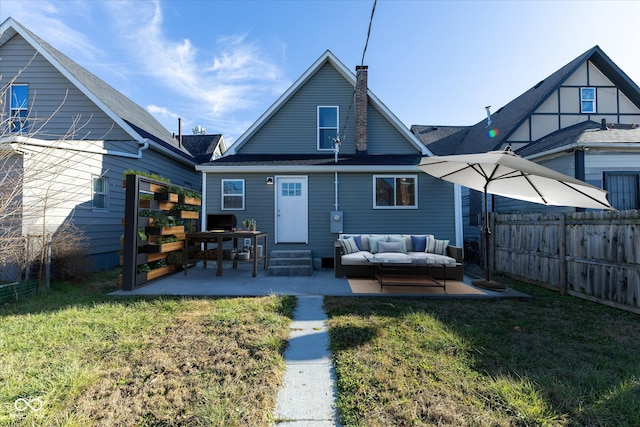 rear view of house with a lawn, an outdoor hangout area, and a patio