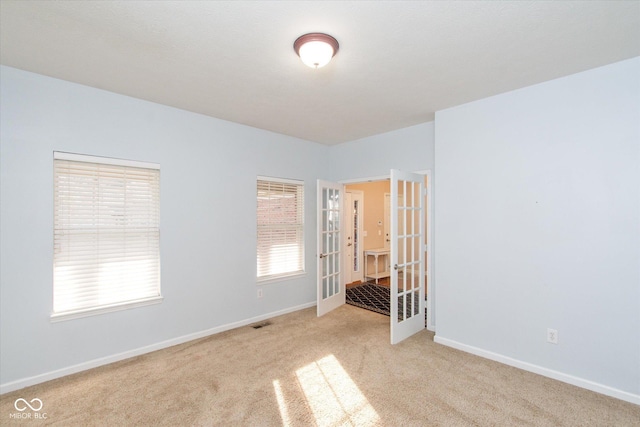 spare room with light carpet and french doors