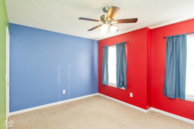 carpeted spare room featuring ceiling fan