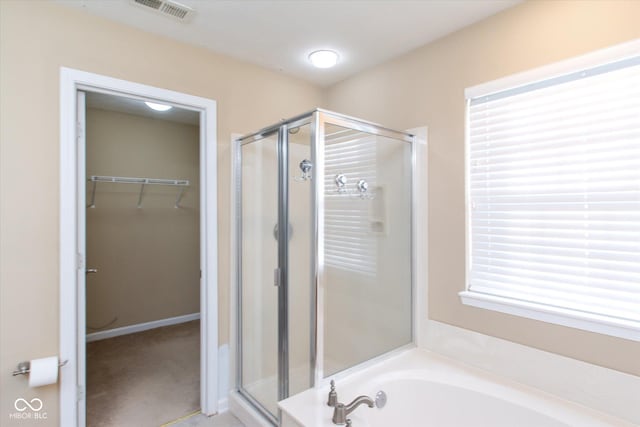 bathroom featuring independent shower and bath and a healthy amount of sunlight