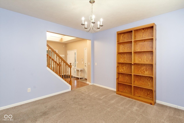 carpeted empty room with an inviting chandelier