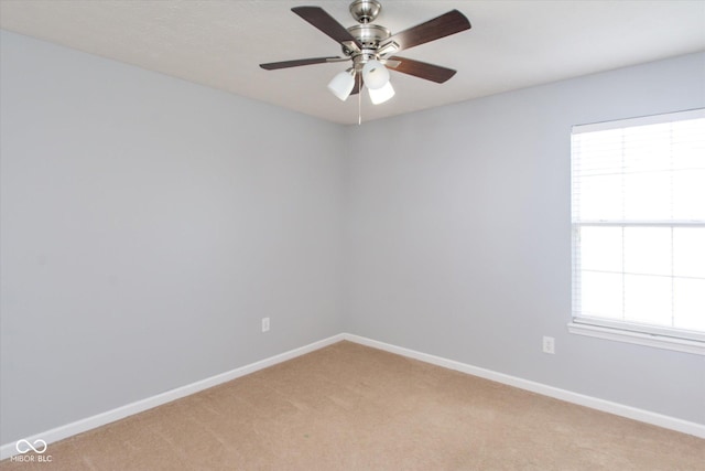 carpeted spare room featuring ceiling fan and a healthy amount of sunlight