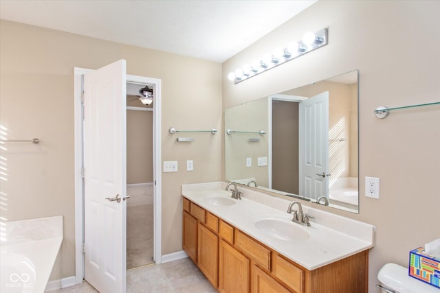 bathroom featuring a tub, ceiling fan, vanity, and toilet