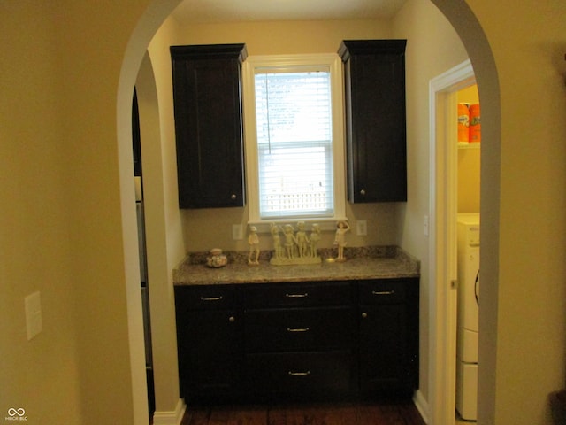 kitchen featuring light stone countertops and washer / dryer