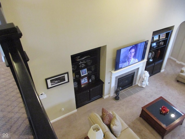 living room with carpet flooring and a tiled fireplace