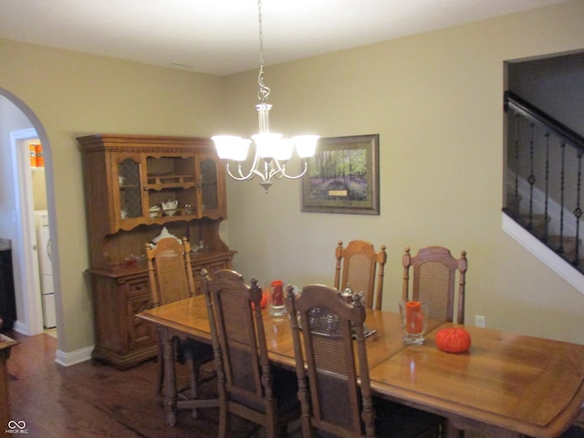 dining space featuring dark wood-type flooring, washer / clothes dryer, and a chandelier