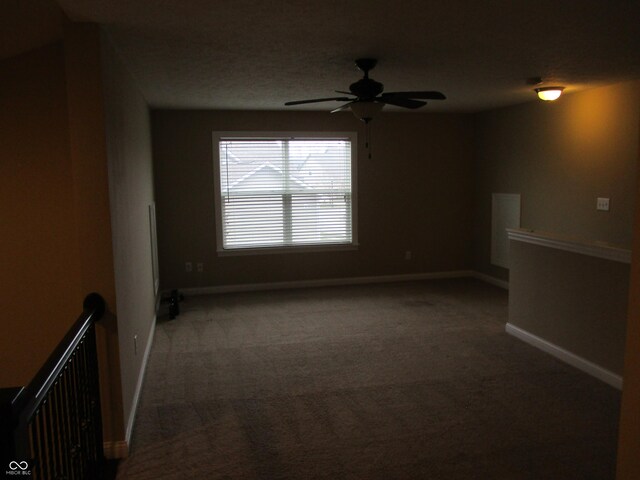 empty room with ceiling fan, radiator heating unit, and dark colored carpet