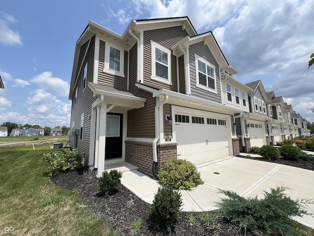 townhome / multi-family property with a front yard and a garage