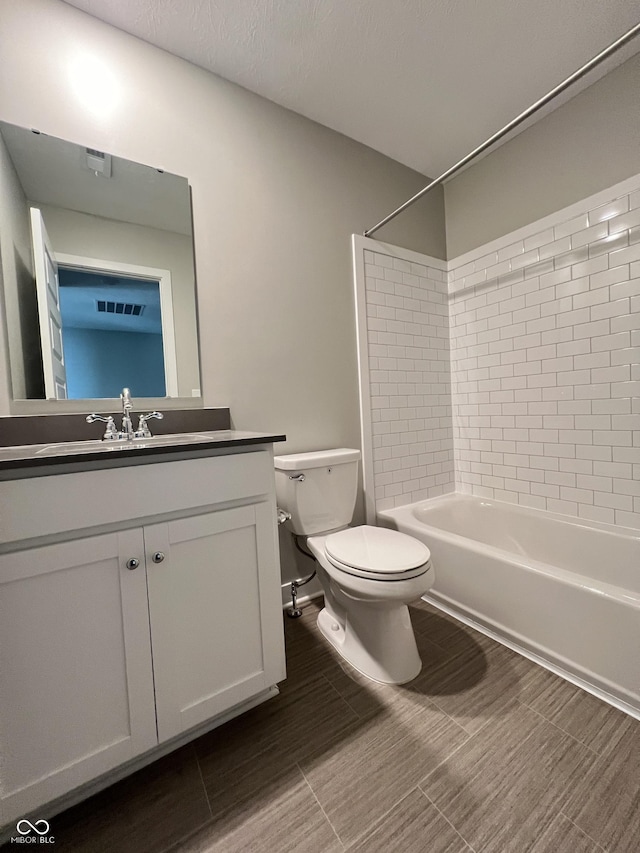 full bathroom with vanity, tiled shower / bath combo, and toilet