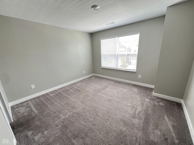 carpeted empty room with a textured ceiling