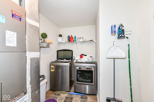 washroom featuring separate washer and dryer, hardwood / wood-style floors, and heating unit