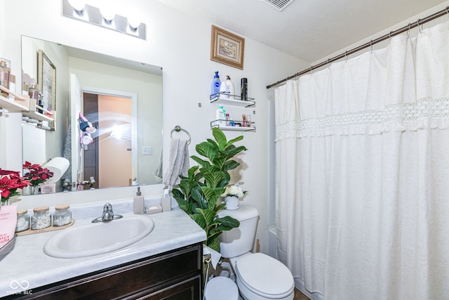 bathroom with vanity, a shower with curtain, a textured ceiling, and toilet