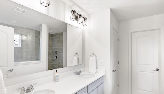 bathroom featuring vanity and tiled shower