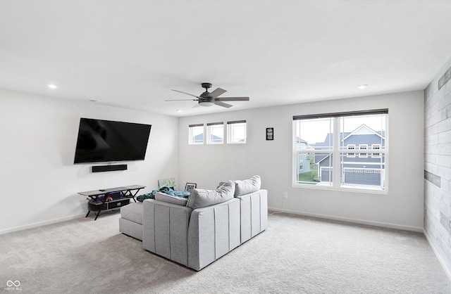 living room featuring light carpet, ceiling fan, and a healthy amount of sunlight