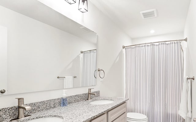 bathroom featuring vanity, toilet, and walk in shower