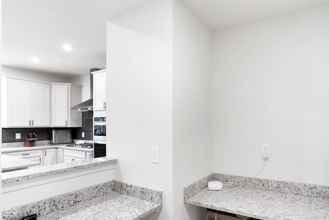 kitchen featuring light stone counters and white cabinetry