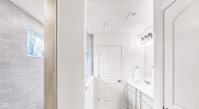 bathroom with a textured ceiling and vanity