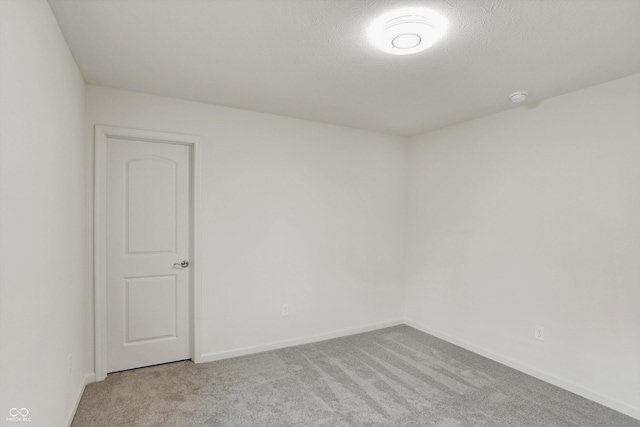 carpeted spare room with a textured ceiling