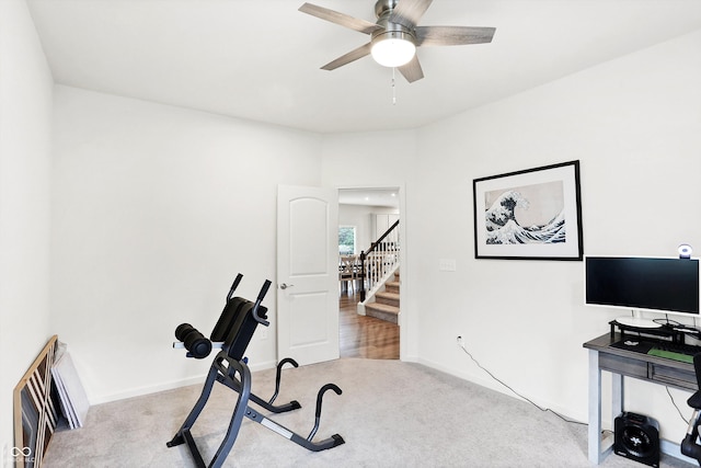 exercise room with ceiling fan and light colored carpet