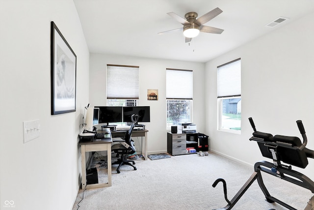 office space featuring light carpet, ceiling fan, and a healthy amount of sunlight