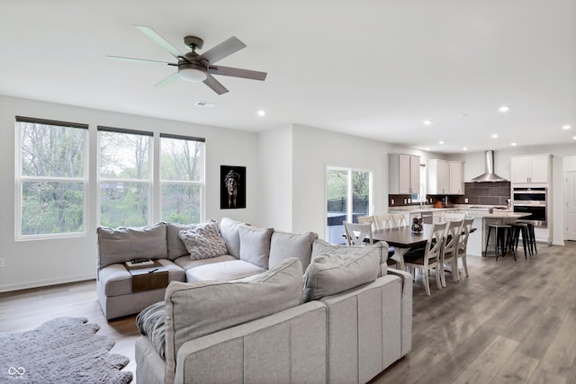 living room featuring ceiling fan and light hardwood / wood-style floors