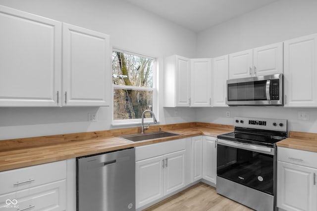 kitchen featuring white cabinetry, appliances with stainless steel finishes, and wooden counters