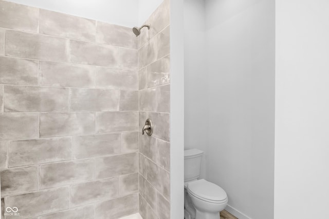 bathroom with toilet and tiled shower