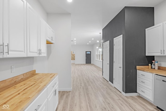 kitchen with wood counters, stainless steel dishwasher, light wood-type flooring, decorative light fixtures, and white cabinetry