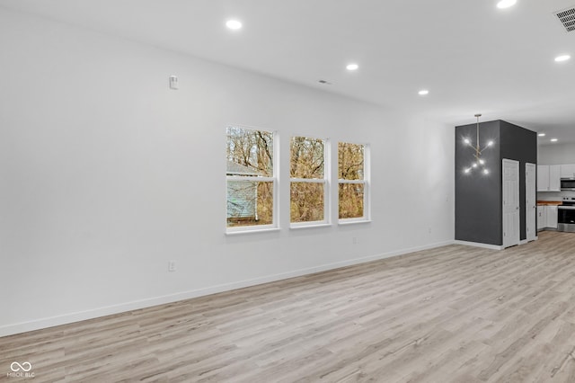 unfurnished living room with a chandelier and light hardwood / wood-style flooring